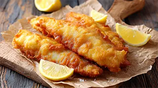 photo of buttermilk fried carp fillets on paper towel with lemon wedges