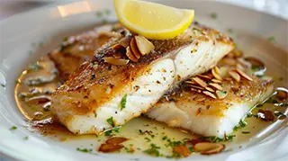 photo of a beautiful plate of catfish almondine with slivered almonds and lemon butter sauce