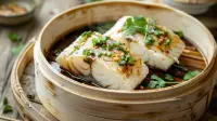 photo of asian steamed sea bass with ginger sauce and chopped onions